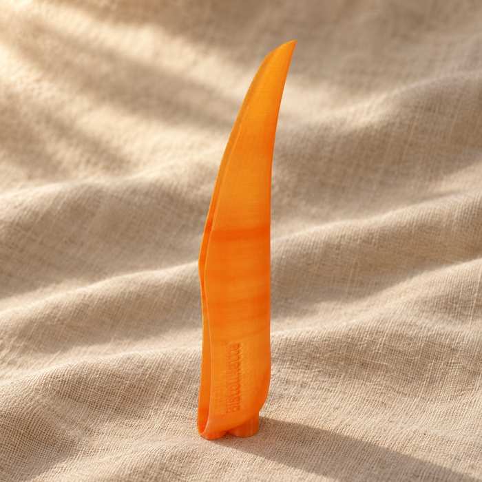 Bistoukette L'Essentielle coloris Orange translucide posée sur un drapé de lin naturel