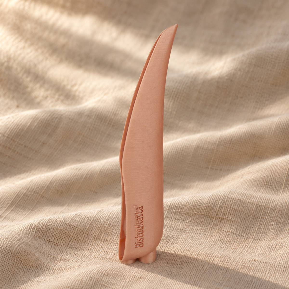 Bistoukette L'Essentielle coloris Cuivrée posée sur un drapé de lin naturel